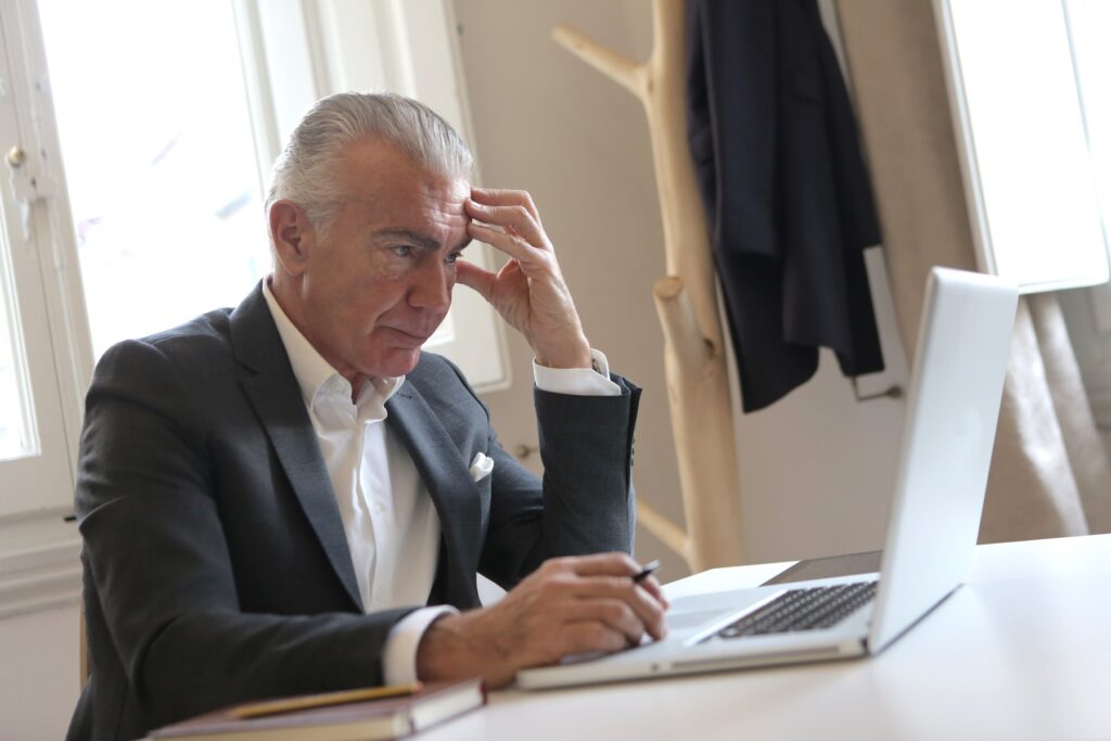 Senior hiring director reviewing candidate profiles on a laptop